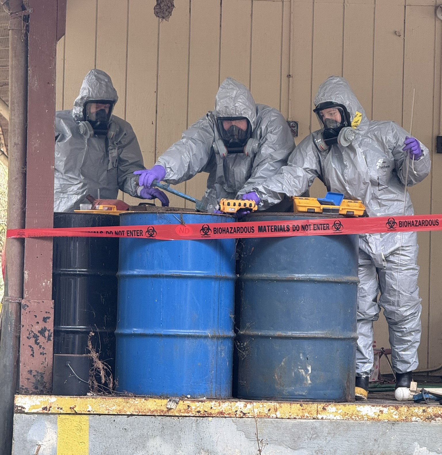 Ecology spills responders in protective gear inspecting and testing barrels at illegal drug operation.